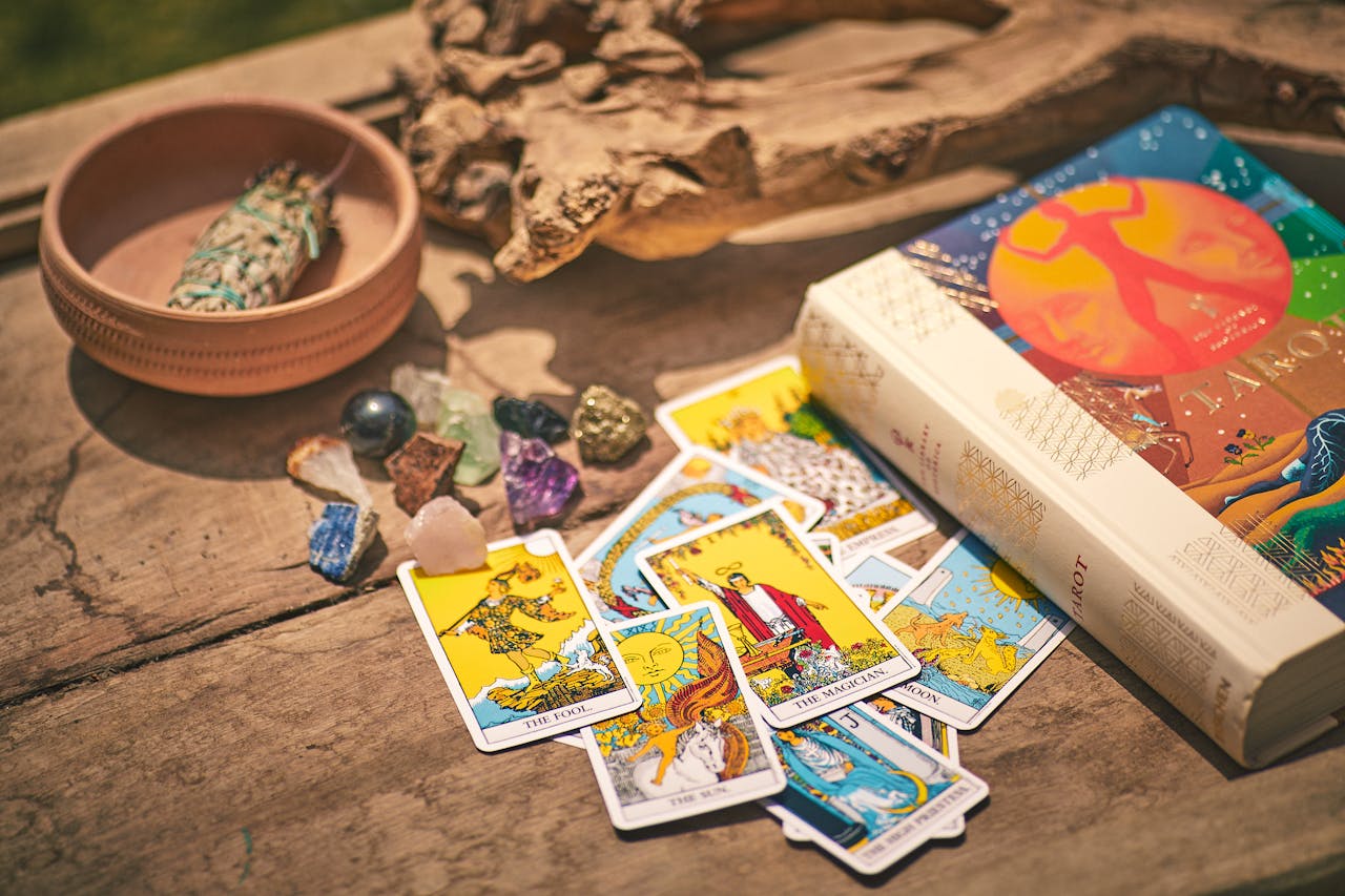 Colorful tarot cards with crystals and sage on rustic table evoke mystical and spiritual themes in Dubai.