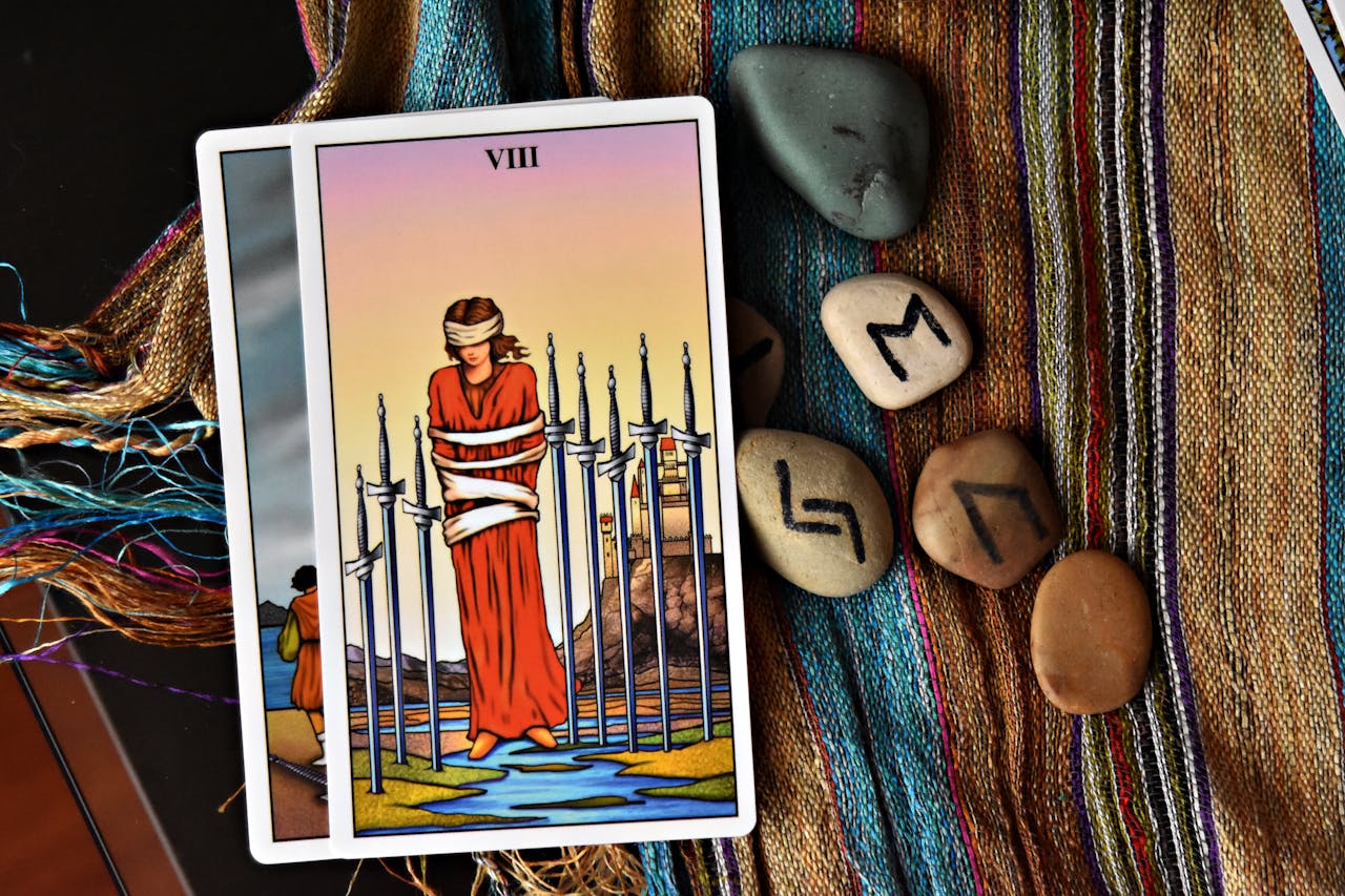 Tarot card with rune stones on colorful fabric, perfect for mystical backgrounds.